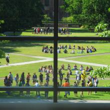 Students stand in circles on a sunny lawn on the UO Eugene campus.