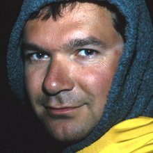 Portrait of doctor Sonke Johnson wearing a gray fleece hood and yellow raingear