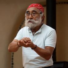 Laurencio Lopez Nunez storytelling with his hands cupped together in front of him.