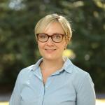 Professional woman with short blond hair and glasses