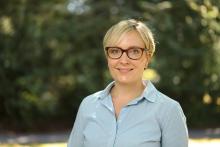 Professional woman with short blond hair and glasses